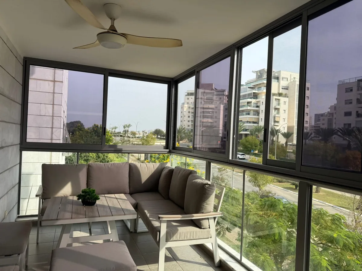 מרפסת סגורה עם ויטרינות ונוף עירוני